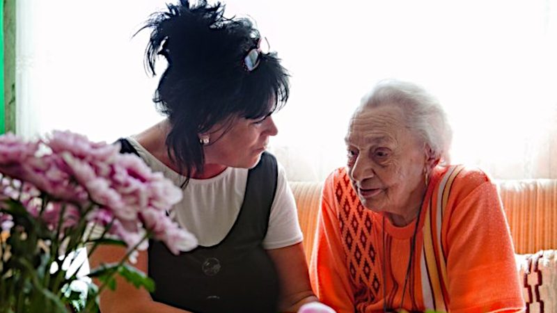 Pflegering und ältere Frau auf dem Sofa