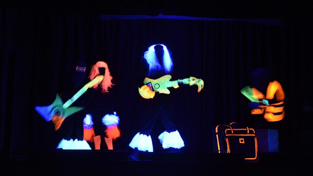 Musiker im Schwarzlicht leuchtende Gitarren und Haare
