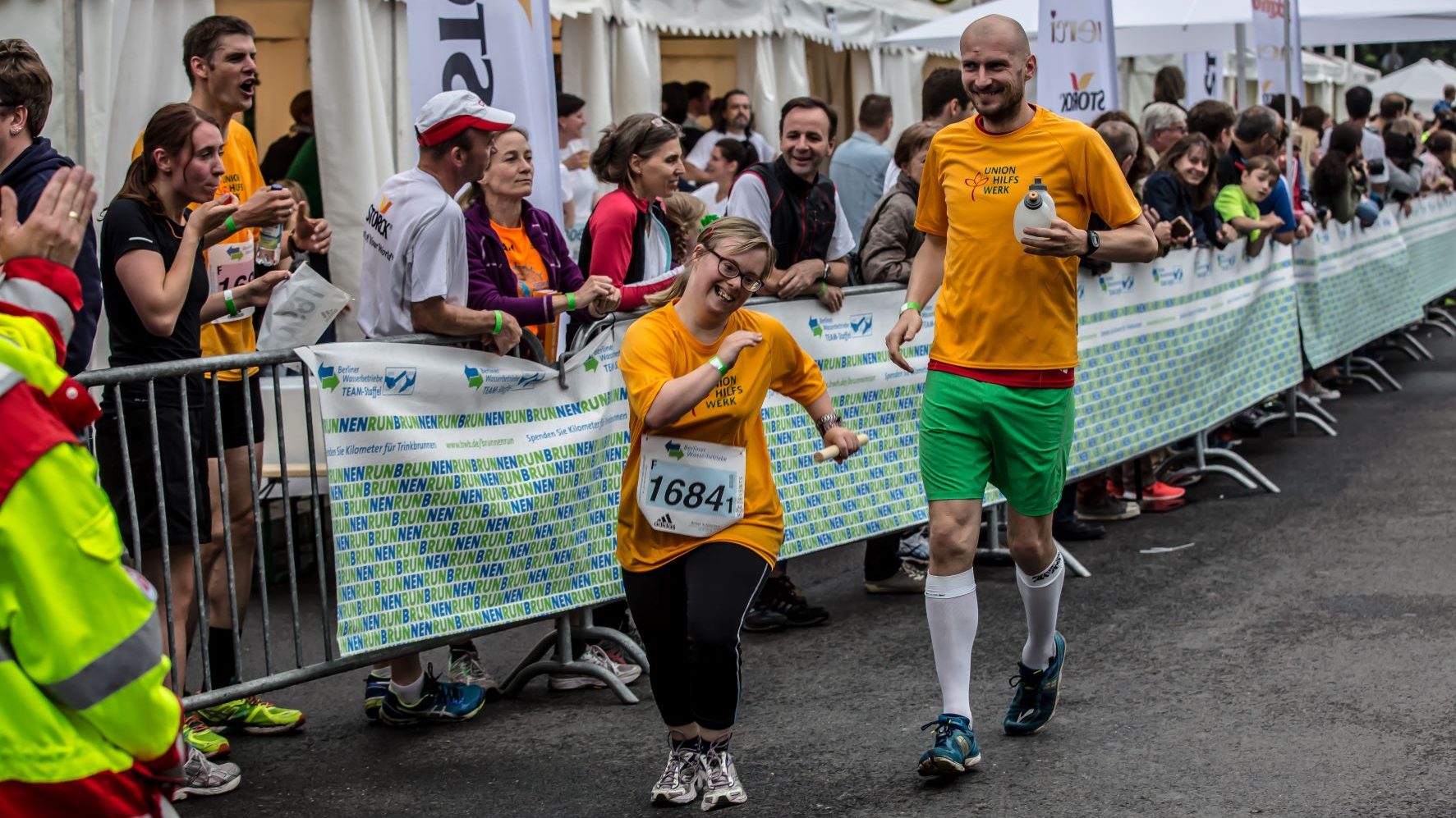 zwei Perosnen Frau und Mann in Laufkleidung an der Seite Publikum