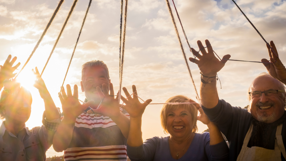 vier Personen die lachen und Hände in die Luft halten