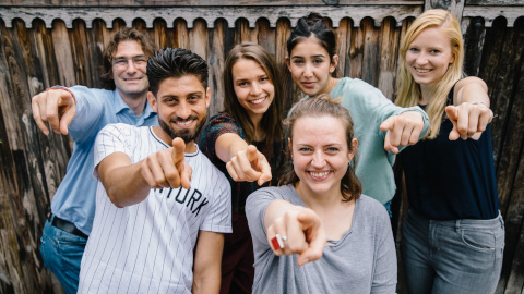 Gruppe junger Menschen, die auf den Betrachter des Fotos zeigen